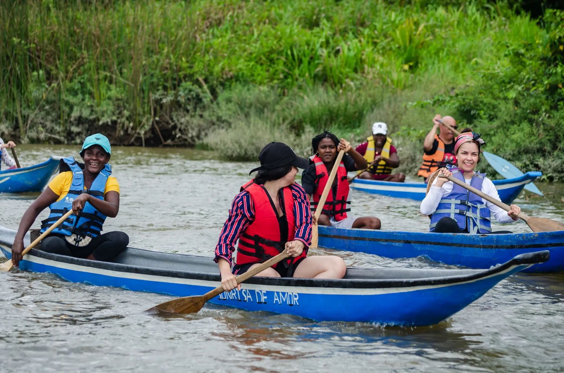 Travellers paddling a potrillo canoe through the Guapi estuaries with local guides